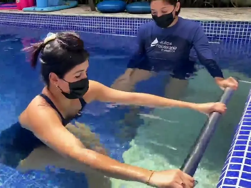 Una fisioterapeuta guía a una paciente durante su sesión en la piscina climatizada